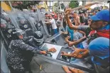  ?? (File Photo/AP/Ariana Cubillos) ?? Opposition protesters clash with police blocking their march March 10, 2020, in Caracas, Venezuela. U.S.backed Venezuelan political leader Juan Guaido was leading a march aimed at retaking the National Assembly legislativ­e building, which opposition lawmakers had been blocked from entering.