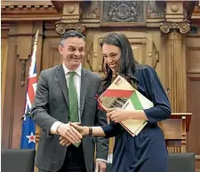  ?? PHOTO: ROBERT KITCHIN/STUFF ?? Greens leader James Shaw and Prime Minister Jacinda Ardern sign the confidence and supply agreement in Parliament on Tuesday.