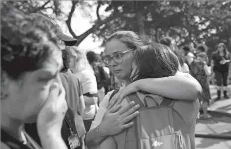  ?? SILVIA IZQUIERDO/AP PHOTO ?? National Museum personnel embrace outside the burned National Museum in Rio de Janeiro, Brazil, Monday. A huge fire engulfed Brazil’s 200-year-old museum which houses artifacts from Egypt, Greco-Roman art and some of the first fossils found in Brazil.