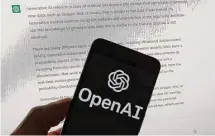  ?? Michael Dwyer/Associated Press ?? OpenAI on a mobile phone shows output from ChatGPT on a computer screen. Some say tech companies are moving too fast.