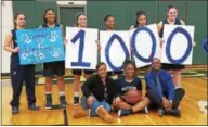  ??  ?? Pottstown senior Ebony Reddick, seated center, between her parents Tawana and Eric Reddick, poses with family and teammates after scoring her 1,000th career point.