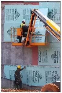  ?? Arkansas Democrat-Gazette/THOMAS METTHE ?? Constructi­on workers fasten insulation board to a wall Friday at the new Jacksonvil­le High School.