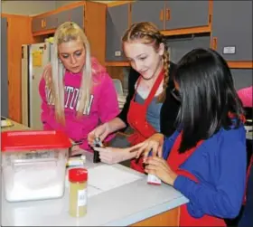  ?? LISA MITCHELL - DIGITAL FIRST MEDIA ?? Fleetwood teacher Alyssa Carl, far left, with Veda Hartman, grade 8, and Naomi Villasenor, grade 5, making cookies for Keystone Villa residents on Martin Luther King Jr. Day, Jan. 15.