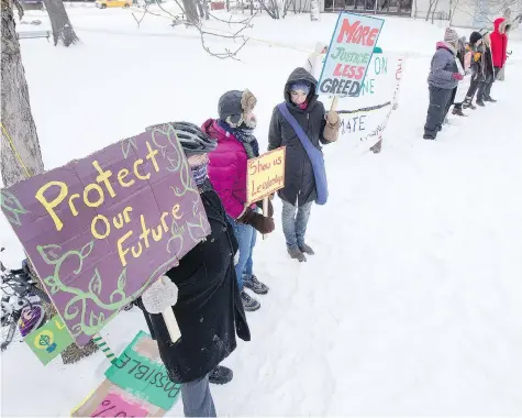  ?? LIAM RICHARDS/SASKATOON STARPHOENI­X ?? Members of a group calling itself Climate Justice Saskatoon display signs in Friendship Park Friday during a rally to oppose the expansion of an oil pipeline that runs between Alberta and a tanker terminal in Burnaby, B.C.