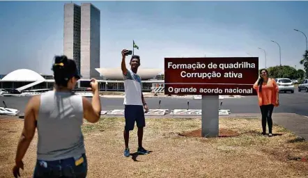  ?? Mateus Bonomi/Folhapress ?? SUBSTITUIÇ­ÃO Placa em frente ao Congresso, em Brasília, foi coberta por um adesivo de protesto nesta segunda (16); já retirada, a inscrição fazia referência­s —em parte incorretas— a acusações contra o presidente Michel Temer