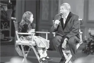  ?? Richard Brian Associated Press ?? HIS SECOND ACT Jerry Lewis jokes with Abbey Umali, 9, at the 2008 Muscular Dystrophy Assn. telethon. As its host for 44 years, Lewis helped raise more than $1 billion for what he referred to as “my kids.”