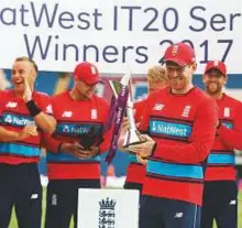  ?? AFP ?? England’s Eoin Morgan (centre) with the series trophy as England players celebrate winning the Twenty20 (T20) internatio­nal cricket series against South Africa at Sophia Gardens cricket ground in Cardiff, Wales, on Sunday.