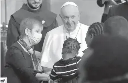  ?? ANDREAS SOLARO/GETTY-AFP ?? Pope Francis greets a woman holding a child Friday after a prayer with migrants at the Roman Catholic Church of the Holy Cross in Nicosia, Cyprus.