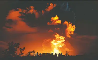  ?? JANICE WEI / NATIONAL PARK SERVICE VIA THE ASSOCIATED PRESS ?? Spectators on Hawaii's Big Island watch as Kilauea erupts on Sunday. The volcano, the most active of the five in the Hawaiian chain, shot steam and an ash cloud into the atmosphere for about an hour.