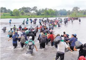 ?? DIANA ULLOA/ASSOCIATED PRESS ?? Salvadoran migrants cross the Suchiate river, the border between Guatemala and Mexico, on Friday. It is the third caravan of migrants trying to reach the United States.