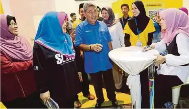  ??  ?? NORASHIKIN (dua dari kiri) dan Ahmad Bashah (tengah) beramah mesra bersama pengunjung.