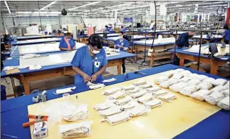  ?? AP-Michael Holahan/The Augusta Chronicle via AP ?? Latricia Lewis prepares finished masks for packaging at the Carole Fabrics facility in Augusta . Carole Fabrics has converted its factory from manufactur­ing drapes and window coverings to now making coronaviru­s masks.