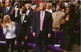  ?? Evan Vucci / Associated Press ?? Republican presidenti­al candidate Donald Trump swayed with the music during a church service at Great Faith Ministries Internatio­nal on Saturday in Detroit.