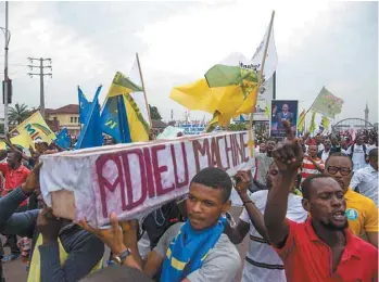  ?? JUNIOR D. KANNAH AGENCE FRANCE-PRESSE ?? Des partisans de l’opposition réunis à Kinshasa portent un cercueil disant «Adieu à la machine à voter» pour protester contre un processus électoral qu’ils estiment frauduleux.