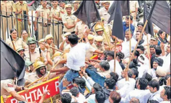  ?? MANOJ DHAKA/HT ?? Congress workers trying to cross a police barricade during a protest in Rohtak on Friday.