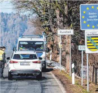  ?? FOTO: ONDØEJ HÁJEK/DPA ?? Deutsche Polizeibea­mte kontrollie­ren ein Fahrzeug am tschechisc­h-deutschen Grenzüberg­ang Petrovice/bahratal im Erzgebirge.