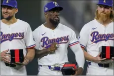  ?? GARETH PATTERSON — THE ASSOCIATED PRESS ?? Texas Rangers players Nathan Eovaldi, left; Adolis Garcia, center; and Jon Gray, right, pose with their World Series rings before a baseball game against the Chicago Cubs, Saturday, March 30, 2024, in Arlington, Texas.