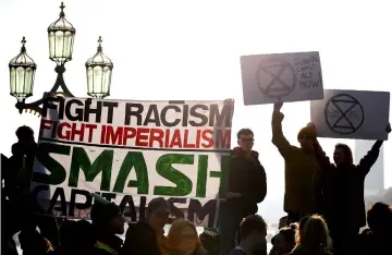  ??  ?? Demonstrat­ors take part in a pro-environmen­t protest as they block Westminste­r Bridge in central London to show anger at what they see as government inaction on climate and ecological issues. — AFP photo