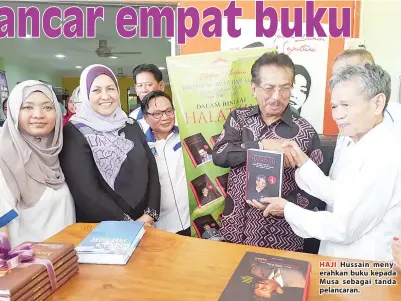  ??  ?? HAJI Hussain menyerahka­n buku kepada Musa sebagai tanda pelancaran.