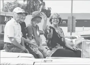  ??  ?? Shaunavon Mayor Sharon Dickie tosses a handful of candy during Saturday's Centennial Parade, with the convertibl­e also saluting the efforts of former mayors Norm Lavoy, Bruce Pearson, Dave Hanna, Ron Froshaug, and Gordon Speirs.