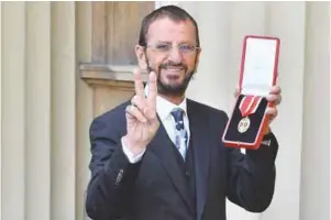  ?? AFPPIX ?? ... Richard Starkey, better known as Ringo Starr, poses with his medal after being appointed Knight Commander of the Order of the British Empire at an investitur­e ceremony at Buckingham Palace in London on Tuesday. The Beatles drummer received the award 21 years after his bandmate Paul McCartney was knighted.