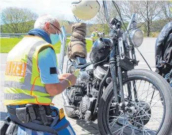  ?? FOTO: LANG ?? Polizeikom­missar Peter Lehmann überprüft, ob bei der Harley Davidson, Baujahr 1950, alles in Ordnung ist.