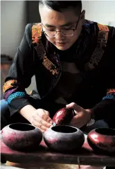  ??  ?? Gao burnishes the lid of a lacquer pot to bring the surface to the highest sheen.