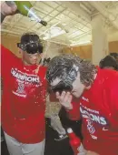  ?? STAFF PHOTO BY JOHN WILCOX ?? THIRSTY FOR MORE: Rafael Devers (left) pours champagne on Andrew Benintendi after Saturday’s AL East-clinching win at Fenway Park.