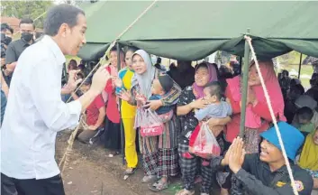  ?? Reuters ?? Indonesian President Joko Widodo talks to people who are sheltered at a temporary tent during his visit to the locations affected by the Monday’s earthquake in Cianjur, on Thursday. —