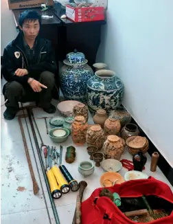  ??  ?? A tomb robber caught by police in Qingshen County, Sichuan Province points to 102 stolen Ming Dynasty artifacts, July 2010