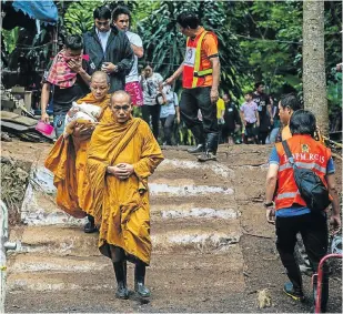  ?? Picture: Getty Images ?? Monks lead family members of the boys from the cave site after a morning prayer yesterday.