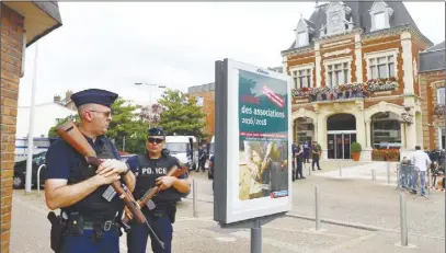  ?? AP PHOTO ?? French police officers stand guard in front of the Saint-Etienne-du-Rouvray’s city hall in Normandy, France, after an attack on a church that left a priest dead.
