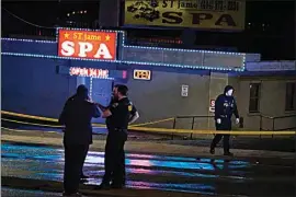  ?? BRYNN ANDERSON / AP ?? In this March 16 file photo, law enforcemen­t officials confer outside a massage business following a shooting in Atlanta.