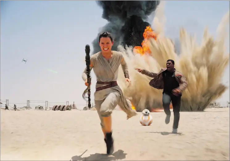  ?? DISNEY FILES ?? Daisy Ridley, left, John Boyega and new robot BB-8 run from an attack from the evil First Order villains in Star Wars: The Force Awakens.