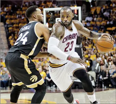  ?? AP/TONY DEJAK ?? Cleveland forward LeBron James (right) looks for room around Toronto guard Norman Powell during Game 2 of Wednesday’s NBA Eastern Conference semifinal. The Cavaliers took a 2-0 series lead after blowing past the Raptors 125-103.