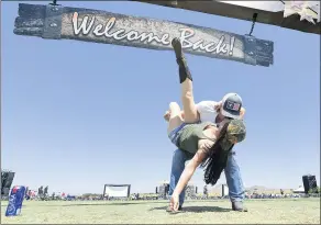  ??  ?? Riley and Julie James share a kiss as they enter the Boots in the Park country music festival.