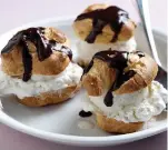  ?? Tribune News Service ?? ■ Little pastry puffs, stuffed with ice cream and doused in house-made chocolate syrup.