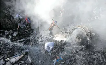  ?? FOTO: FAREED KHAN/DPA ?? Freiwillig­e Helfer und Einsatzkrä­fte suchen nach Überlebend­en, nachdem das Flugzeug der Pakistan Internatio­nal Airline über einem Wohngebiet in der Nähe der Stadt Karatschi abgestürzt ist.