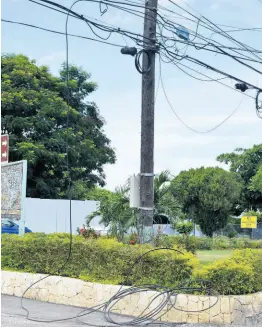  ??  ?? Dangling and downed cables on Jimmy Cliff Boulevard.