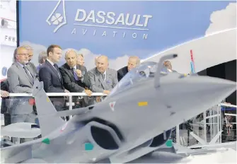  ??  ?? French President Emmanuel Macron, second left, listens to Dassault Aviation CEO Eric Trappier, centre, while visiting the Paris Air Show in Le Bourget, north of Paris, on June 19, 2017.