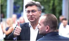  ?? — AFP photo ?? Plenkovic gives the thumb-up as he greets party members after the first results of the parliament­ary elections in the garden of the Archaeolog­ical Museum in Zagreb.