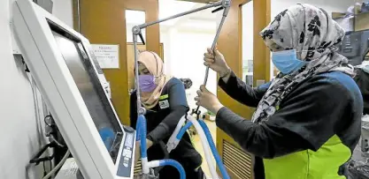  ?? —LYN RILLON ?? CHALLENGIN­G TIMES FOR PGH Two respirator­y therapists set up a mechanical ventilator for COVID-19 patients at the critical care unit of the Philippine General Hospital on Thursday. The government-run hospital is currently trying the convalesce­nt plasma therapy to treat the disease.