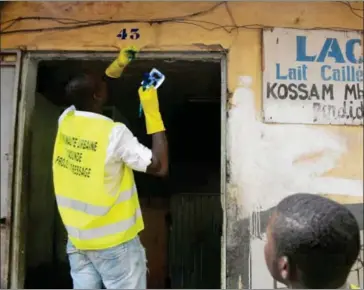  ?? REINNIER KAZE/AFP ?? A Cameroonia­n painter working on behalf of the Yaounde municipali­ty applies numbers to houses in Yaounde on August 9.