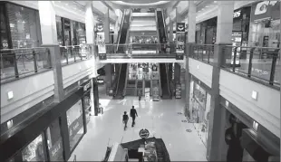  ??  ?? PETAH TIKVA
People walk inside a shopping mall with most shops shuttered due to coronaviru­s disease (COVID-19) restrictio­ns, in Petah Tikva, Israel. -REUTERS