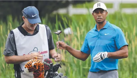  ?? Picture: GETTY IMAGES ?? NEW WAND: Tiger Woods hands his putter to his caddie Joe LaCava during the Pro-Am for the Quicken Loans National.