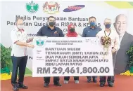  ?? ?? BANTUAN: Hasbi mewakili Mahdzir menyampaik­an BMT 2021 kepada wakil pekebun kecil RISDA Sarawak, Peterim Jimbau.