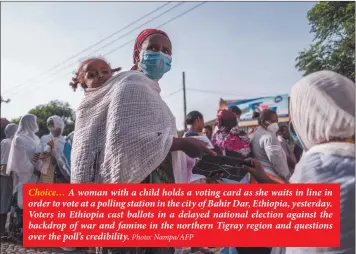  ?? Photo: Nampa/AFP ?? Choice… A woman with a child holds a voting card as she waits in line in order to vote at a polling station in the city of Bahir Dar, Ethiopia, yesterday. Voters in Ethiopia cast ballots in a delayed national election against the backdrop of war and famine in the northern Tigray region and questions over the poll’s credibilit­y.