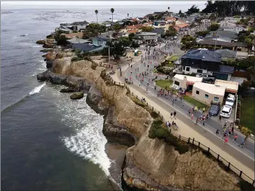  ?? PHOTOS BY SHMUEL THALER — SANTA CRUZ SENTINEL ?? Runners stride through Pleasure Point on Sunday during the 50th annual Wharf to Wharf Race.