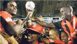  ?? FILE ?? Arnett Gardens players celebrate with the Red Stripe Premier League trophy after winning the 2016-17 title.