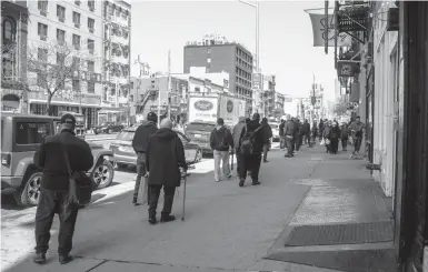  ?? ANDREW SENG/THE NEW YORK TIMES ?? People wait for meals March 22 at the Bowery Mission in Manhattan. Some Americans who would benefit most from the government’s stimulus payments amid the pandemic are having the hardest time getting it for a variety of reasons.